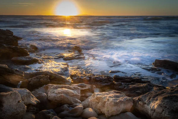 Rocky shore under a shining sun at sunset — Stock Photo, Image