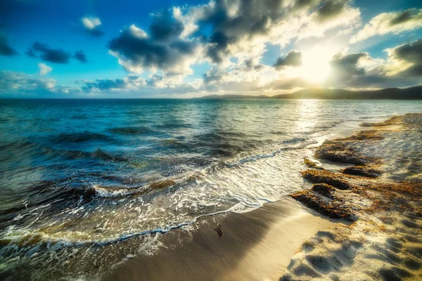 Vågor i Alghero sandstrand vid solnedgången — Stockfoto