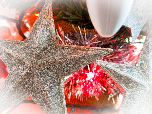 Close up de estrelas de prata em uma árvore de Natal com luzes vermelhas acesas — Fotografia de Stock