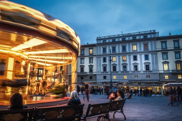 Pessoas por um carrossel vintage em Florença à noite — Fotografia de Stock