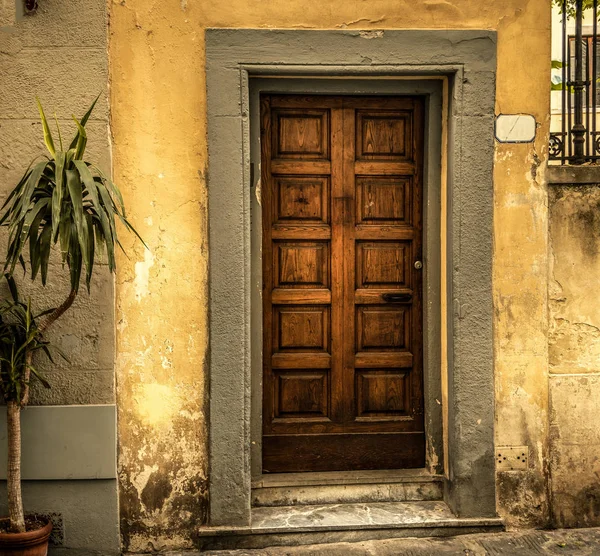 Rustic wooden door and grunge facade in Florence — Stock Photo, Image