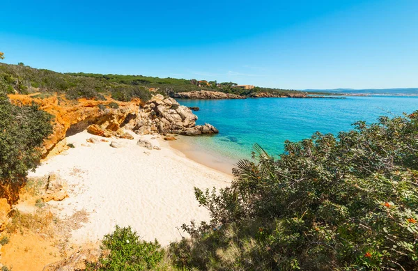 Cielo azzurro e mare azzurro in una piccola insenatura in riva ad Alghero — Foto Stock