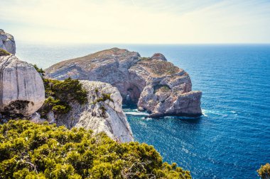 Baharda açık bir günde Forada Adası ve Capo Caccia uçurumu. Sardunya, İtalya