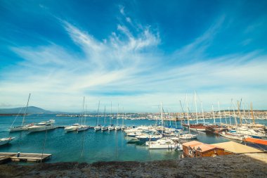 İlkbaharda bulutlu bir gökyüzünün altında Alghero limanı. Sardunya, İtalya