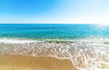 İlkbaharda Perdepera plajı üzerinde açık bir gökyüzü. Sardunya, İtalya