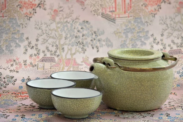 Cracked ceramic teapot and three cups — Stock Photo, Image