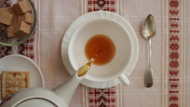 Verter el té en una taza sobre la cabeza tiro — Vídeo de stock