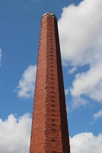 Alta chimenea de ladrillo en el cielo azul — Foto de Stock