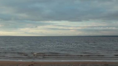 Yavaş yavaş çalışan dalgalar, güzel deniz manzarası, akşam günbatımı, kasvetli bulutlar deniz için göster