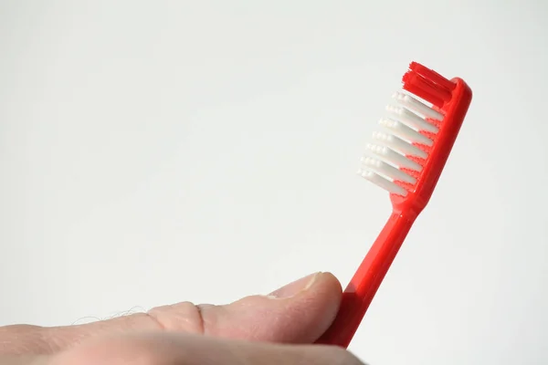 Escova de dentes vermelha na mão — Fotografia de Stock