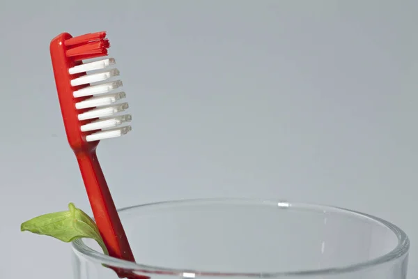 Escova de dentes vermelha em um copo de vidro — Fotografia de Stock
