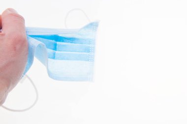 Erkek elinde standart tıbbi maske. Sıkı tut.