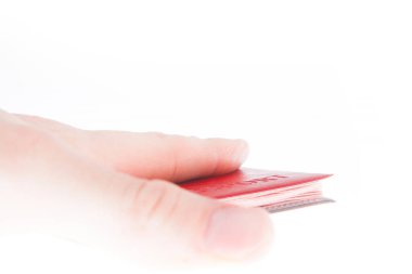 Adam nazikçe bir pasaport tutuyor. Kırmızı belge. Beyazın üzerinde izole.