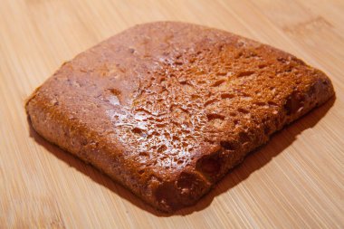 Yemek odası için bir tablo: tahta bir masanın üzerinde dilimlenmiş bir parça ekmek.