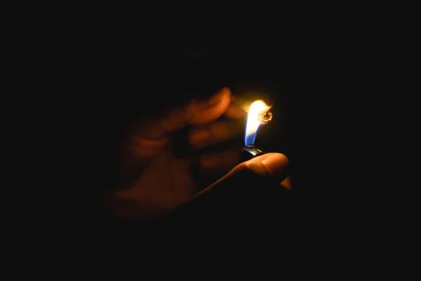 Burning gas lighter and cigaret in men's hand isoleted on black background — Stock Photo, Image