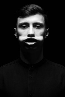 Siyah ve beyaz siyah tişörtlü adam düşük anahtar portresi.