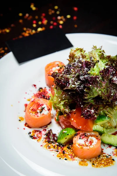 Yaprak sebze salatası ile füme somon. kırmızı balık sağlıklı salata ile karışık marul yaprakları, zeytin ve beyaz bir tabak domates