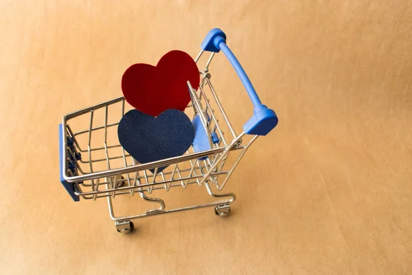 ショッピングカートとクラフトの背景に青と赤の心は署名の場所します。 — ストック写真