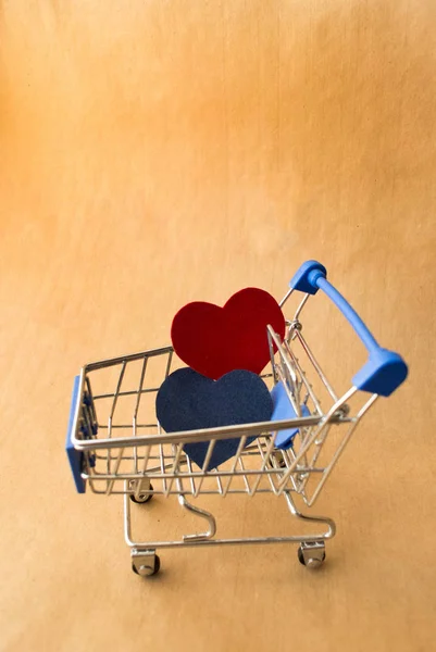 ショッピングカートとクラフトの背景に青と赤の心は署名の場所します。 — ストック写真