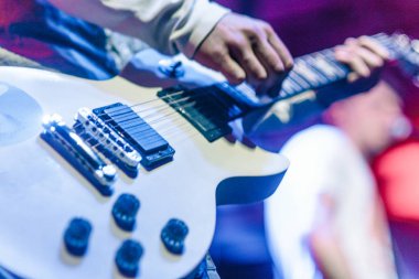 closeup rockstar elektro gitar çalmaya sahnede. Erkek gitarist