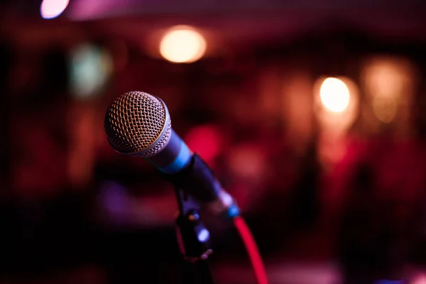 Mikrofon karşı ve müzik notlar renkli ışık arka plan bulanıklık — Stok fotoğraf