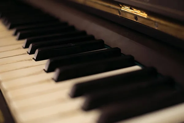 Il vecchio pianoforte nero. primo piano delle chiavi. Bella sfocatura — Foto Stock