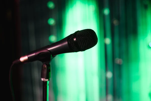 Microfono contro e note musicali sfocatura sfondo luce colorata — Foto Stock