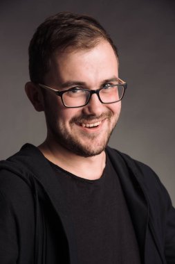 siyah t-shirt gri studio arka planda kameraya poz izole erkekte gülümseyen portresi