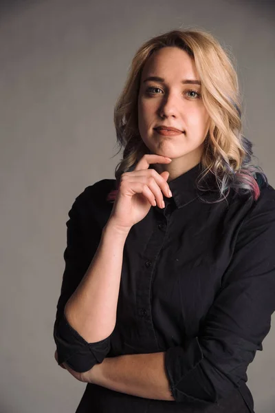 portrait of serious young woman with colored hair in black shirt isolated on gray studio background posing to the camera, bussines woman