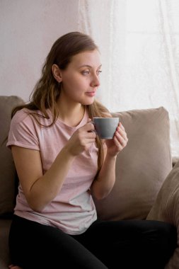 Güzel kadın tarafından kanepede oturan sabah çay içme