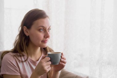Güzel kadın tarafından kanepede oturan sabah çay içme
