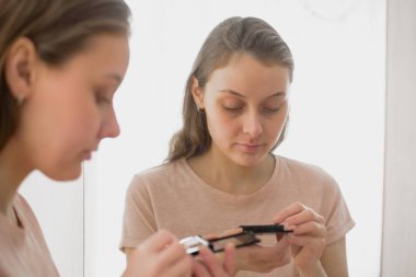 Evde makyaj çekici genç kadın portresi. Göz farı