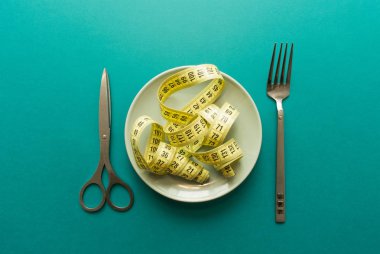 Terzinin metre gibi metal makas ve yeşil zemin üzerine çatal Çin eriştesi plaka üzerinde. en az kavramı. Üstten Görünüm. Diyet, sağlıklı gıda