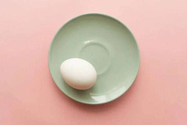 Bir beyaz pastel pembe yumurta. en az kavramı. Üstten Görünüm