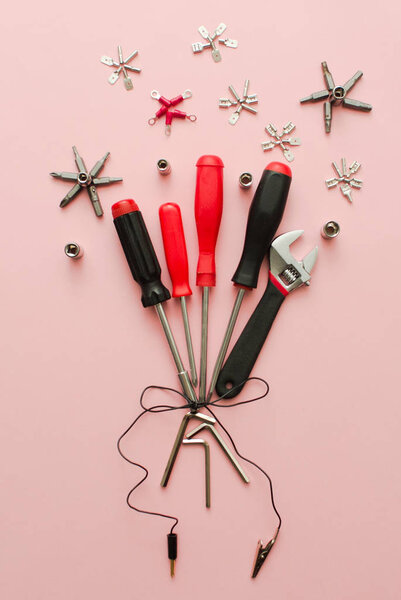 Conceptual set of tools on pink background. It looks like bouquet of flowers for real man. Working handmade instruments. Top view.