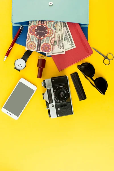 Sevimli kadın çanta düz lay açmak pasaport ile kozmetik, güneş gözlüğü, para, smartphone ve kamera kopya alanı, üstten görünüm ile renkli arka plan üzerinde. Tüm konfor için gereken seyahat. — Stok fotoğraf