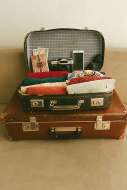 Açık vintage deri seyahat mi veya giysi, pasaport, akıllı telefon, kamera ve konfor yolculuk için güneş gözlüğü ile eski bavul. Yakın çekim