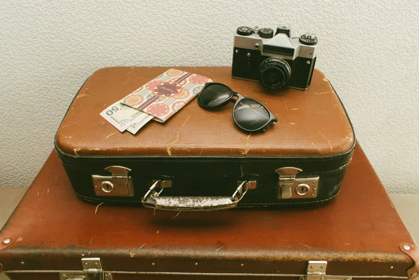 Vintage läder resor kappsäckar eller gammal resväska med pass, pengar, kamera och solglasögon. Närbild — Stockfoto