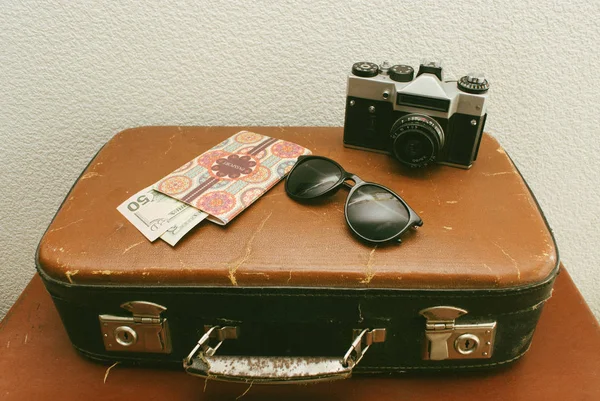 Винтажные кожаные чемоданы или старый чемодан с паспортом, деньгами, фотоаппаратом и солнцезащитными очками. Закрыть — стоковое фото