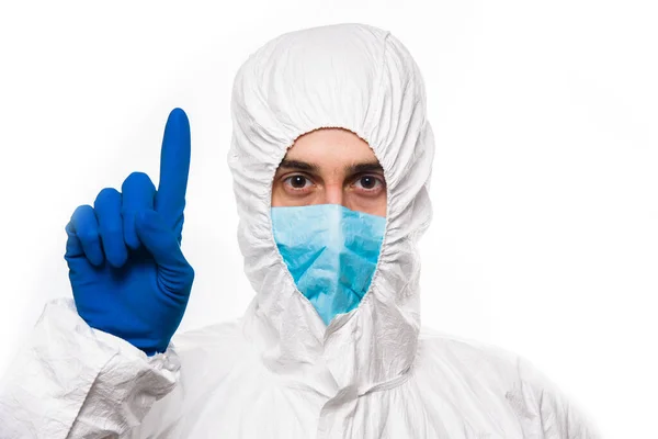 Portrait de jeune homme en uniforme médical blanc protecteur donnant le signe UP pendant la pandémie de coronavirus. Épidémie, pandémie de coronavirus covide 19 . — Photo