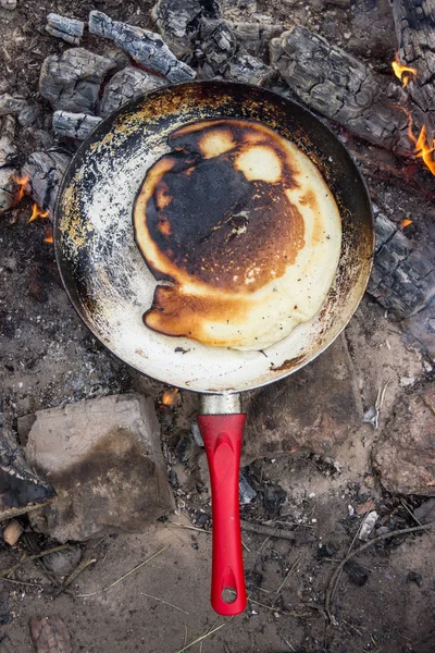 Panqueca cozida em um fogo em uma frigideira com uma caneta vermelha . — Fotografia de Stock