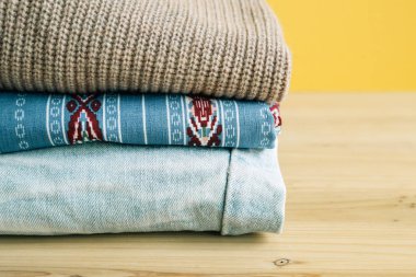 Ahşap masa üzerinde renkli elbise yığını