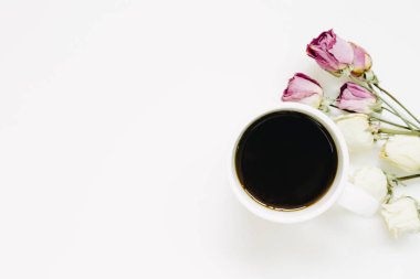 fincan kahve ve beyaz arka plan üzerinde izole kuru gül çiçekler. Üstten Görünüm