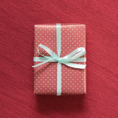 Kırmızı kumaş arka plan üzerinde hediye kutusu