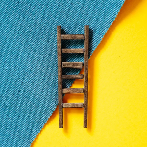 Escalera de madera sobre fondo amarillo y azul — Foto de Stock