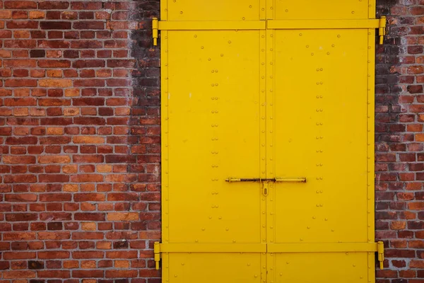 Porte en métal jaune et mur de briques — Photo