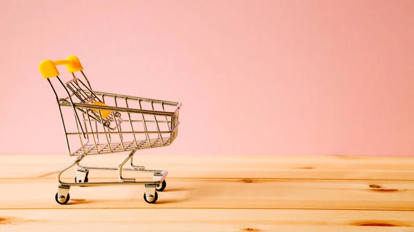 Carrito de compras en mesa de madera — Foto de Stock