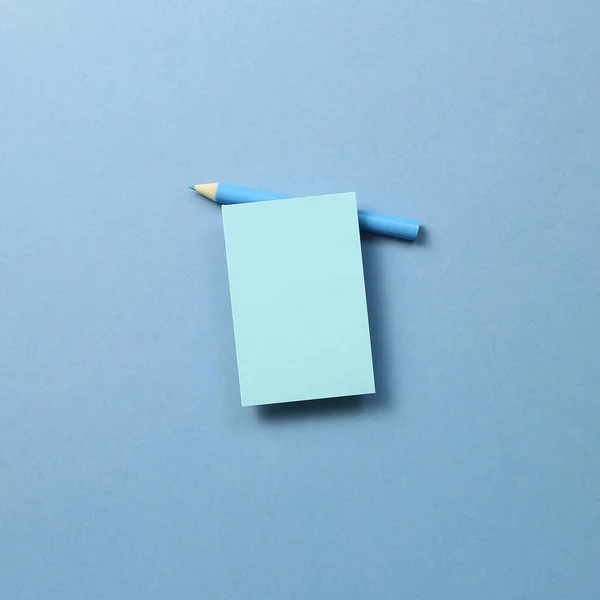 Bloc note note bleu et crayon de couleur bleue sur fond bleu — Photo