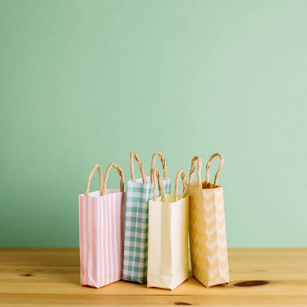 Bolsas de compras de papel colorido en mesa de madera — Foto de Stock