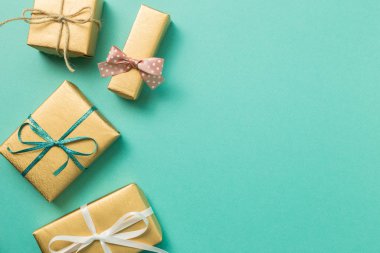 Gold gift box on mint green background